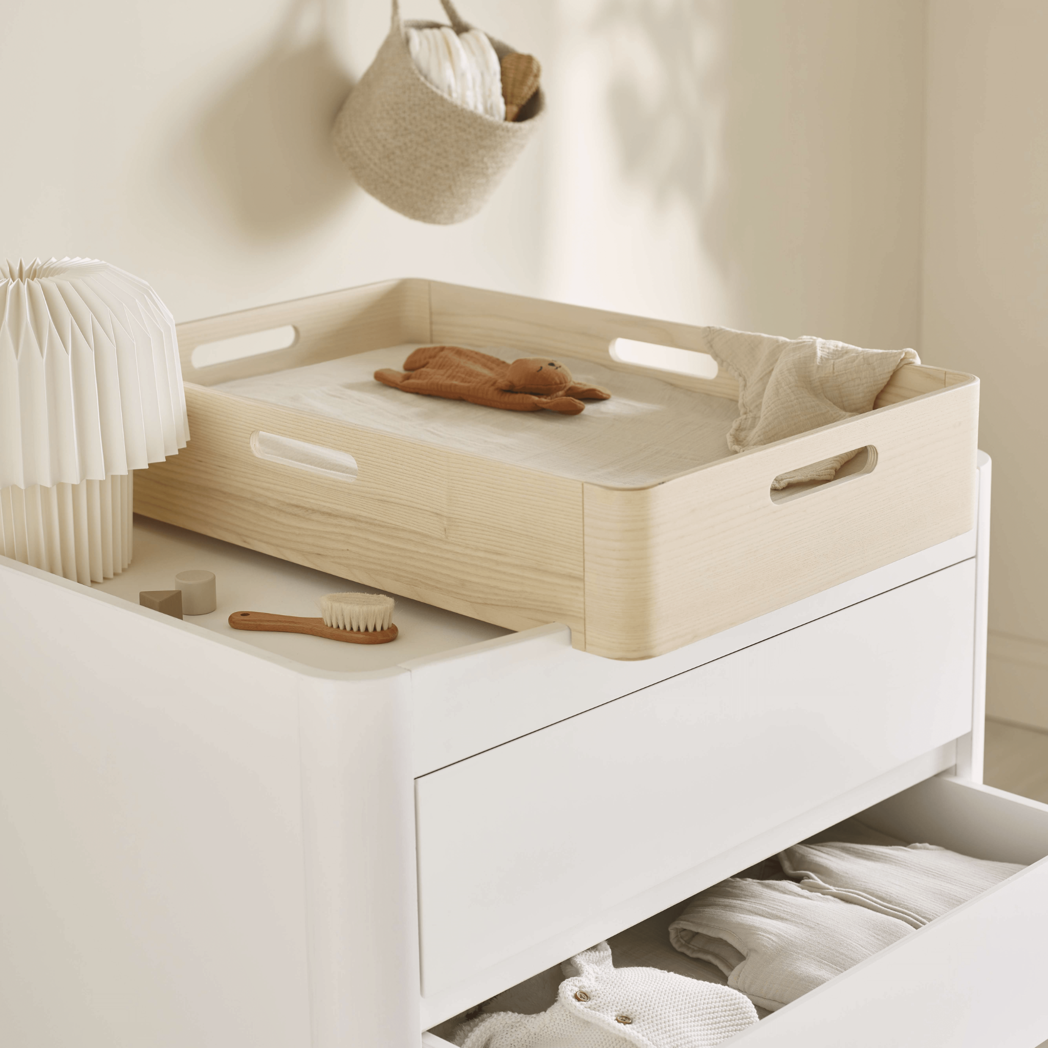 Hera Echtholz-Wickelstation auf der Serena-Kommode in einem beigen Kinderzimmer.