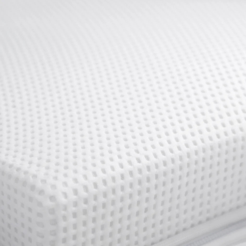 Close-up of Gaia Baby Dual Fibre cot bed mattress corner showing breathable fabric cover.