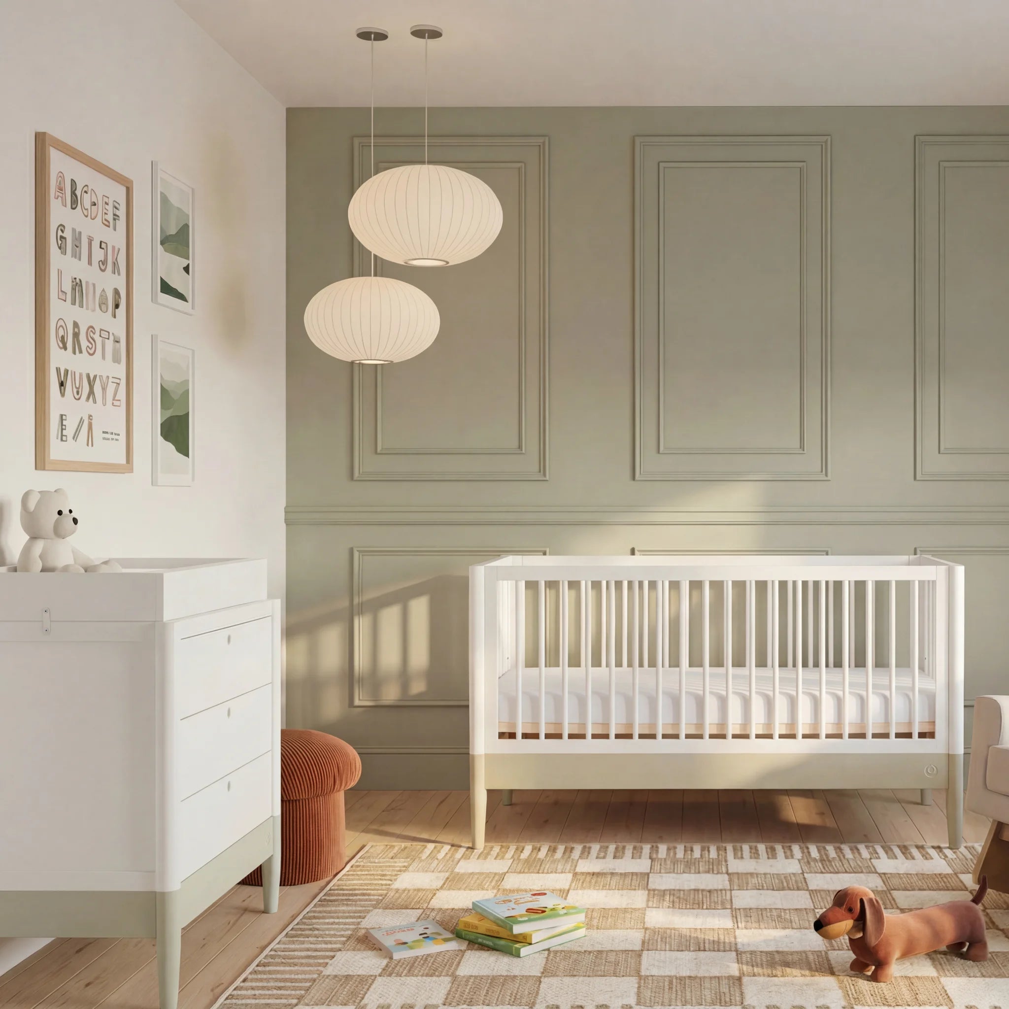 Gaia Baby EOS Convertible Cot in white in a sage green nursery with panelled wall, changing dresser, pendant lights and toys on a checkered rug