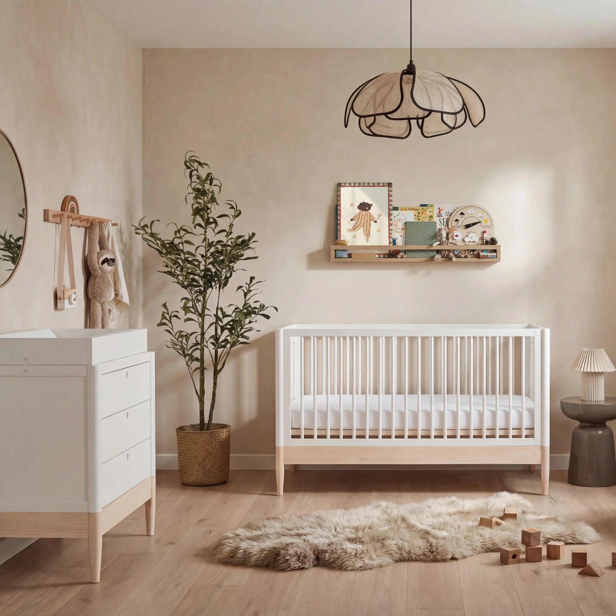 Gaia Baby Eos umwandelbares Kinderbett in Weiß und Naturholz mit passender Kommode in einem neutralen, modernen Kinderzimmer mit Holzboden und weichem Dekor