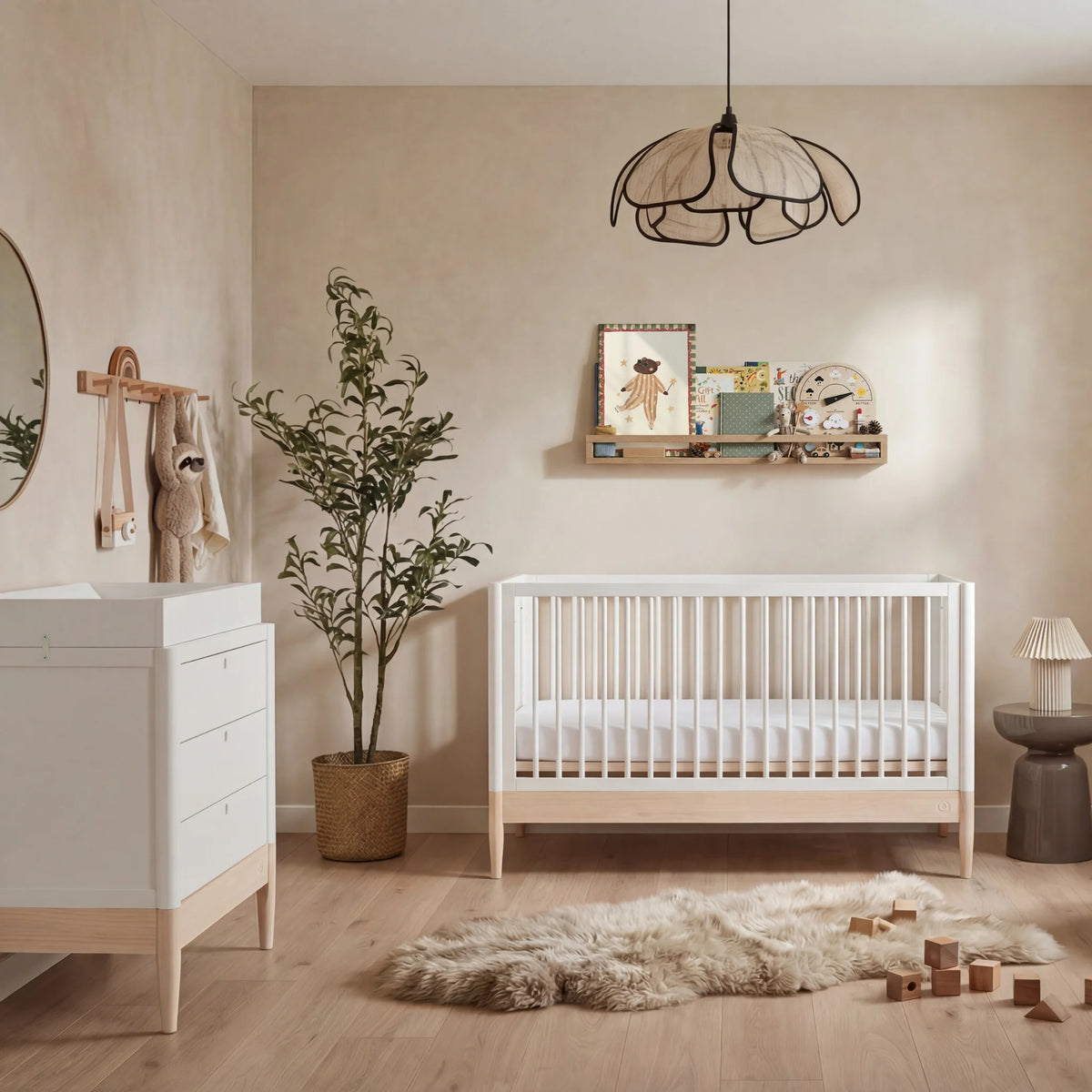 Gaia Baby Eos convertible cot in white and natural wood with matching dresser in a neutral modern nursery with wooden floor and soft decor