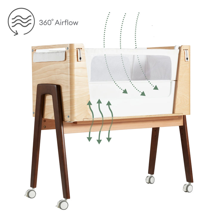 Hera bedside crib in natural ash walnut with 360 airflow icon.