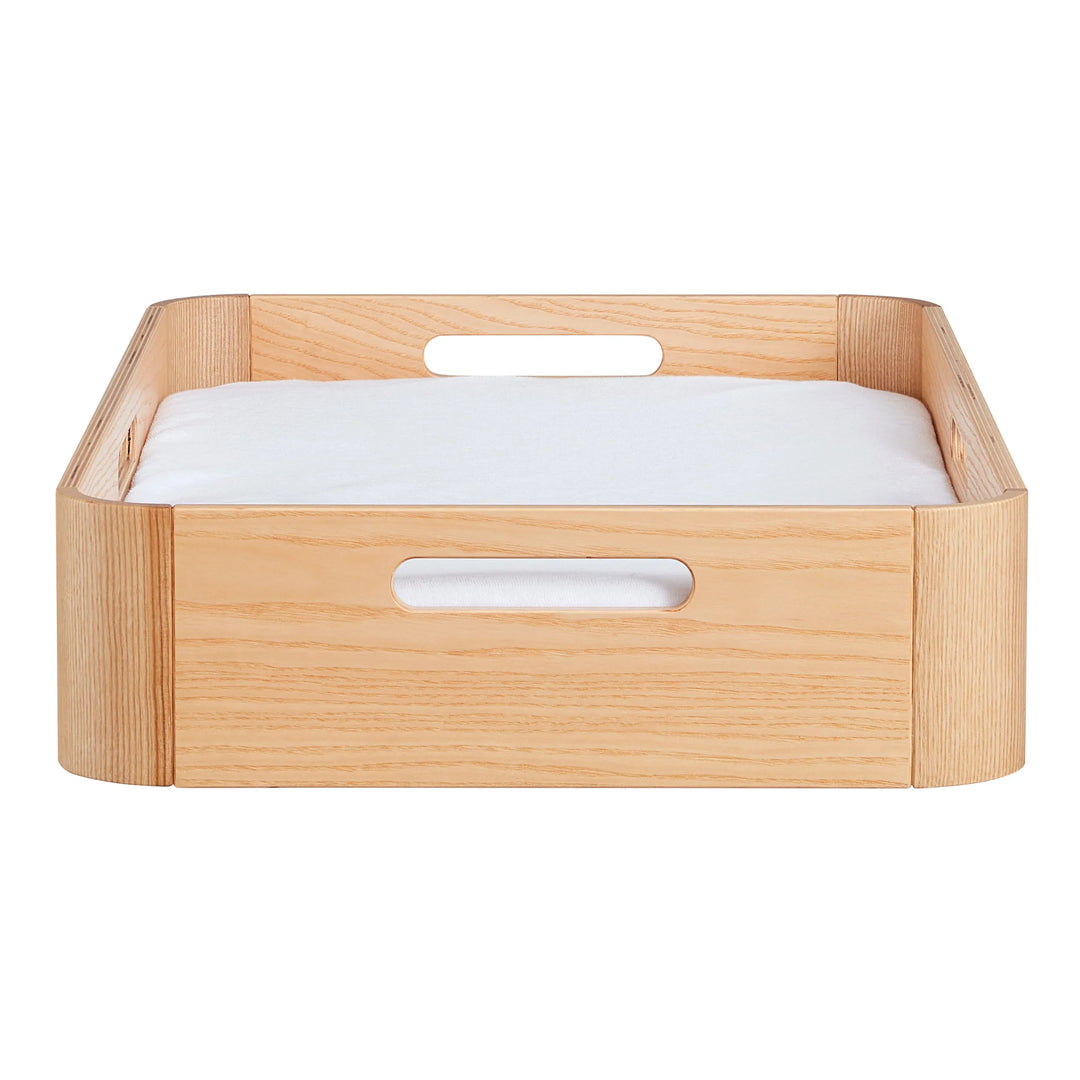 Front view of Gaia Baby portable Hera baby changing station in natural ash wood showing carrying handles and removable waterproof changing pad insert.