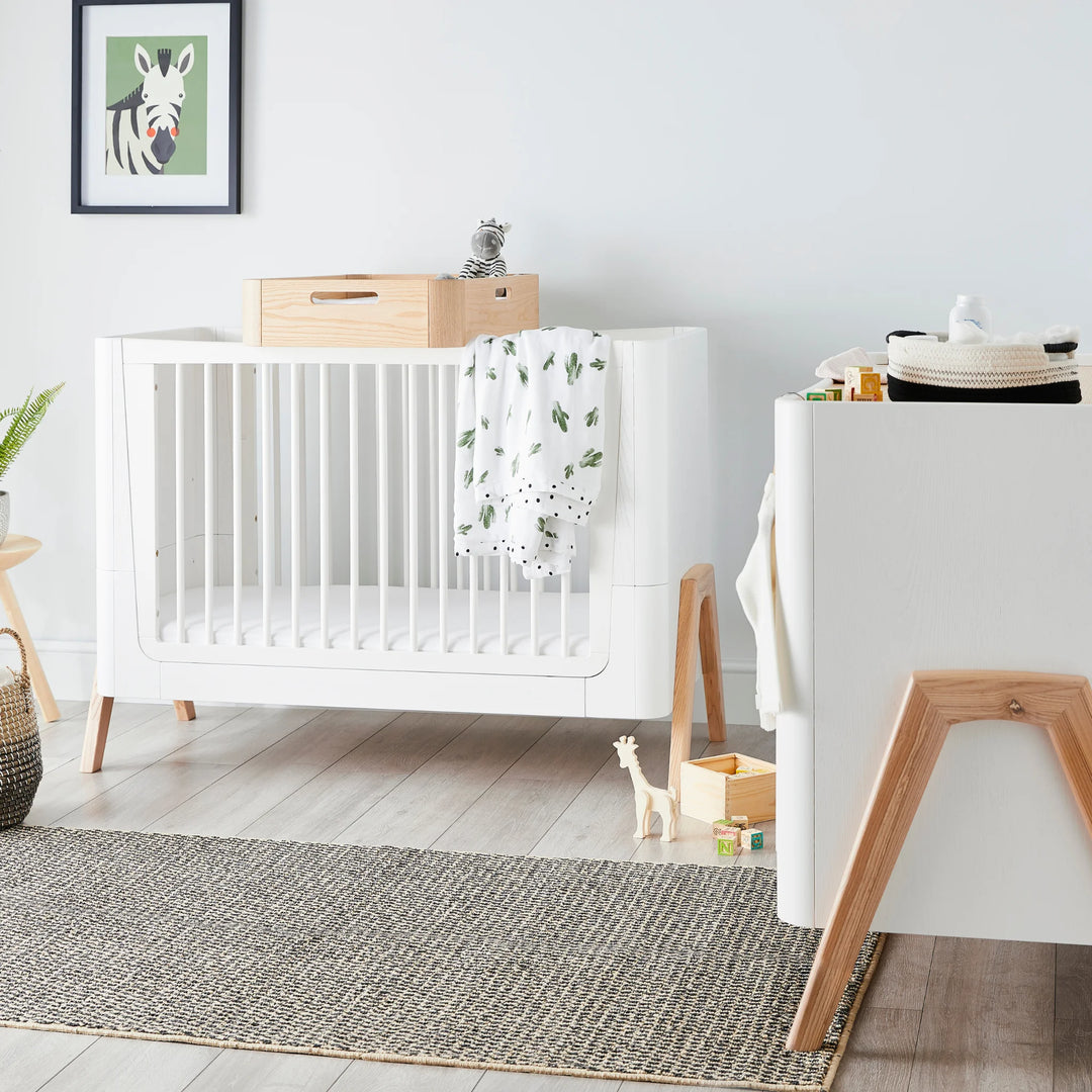 Gaia Baby Hera Cot Bed front view with changing station on top and matching dresser.