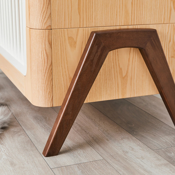 Hera Cot Bed close up of walnut A-frame legs.