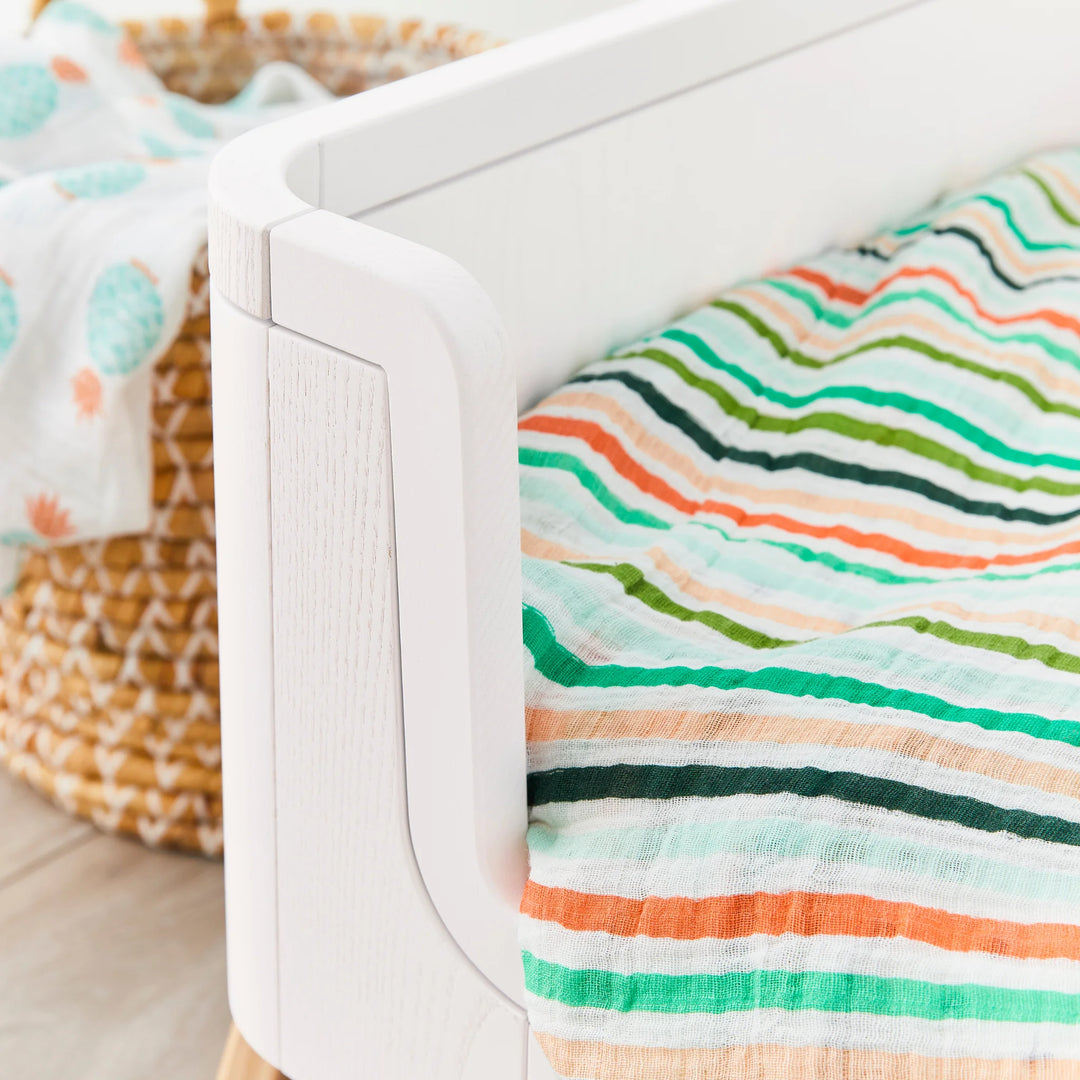 Hera Cot Bed in first bed mode close up of real wood grain.