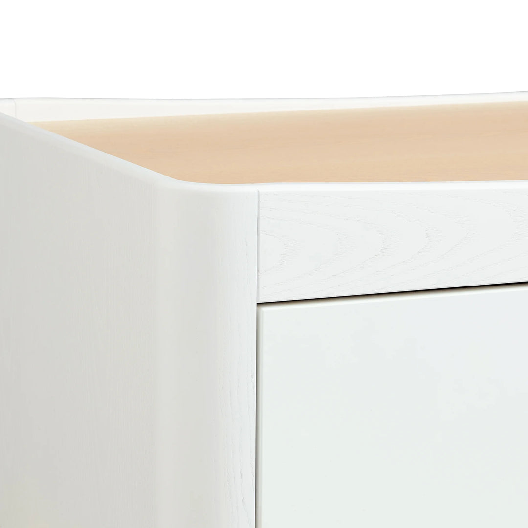 Close up of wood grain and curved edges on the Gaia Baby Hera Dresser in scandi white.
