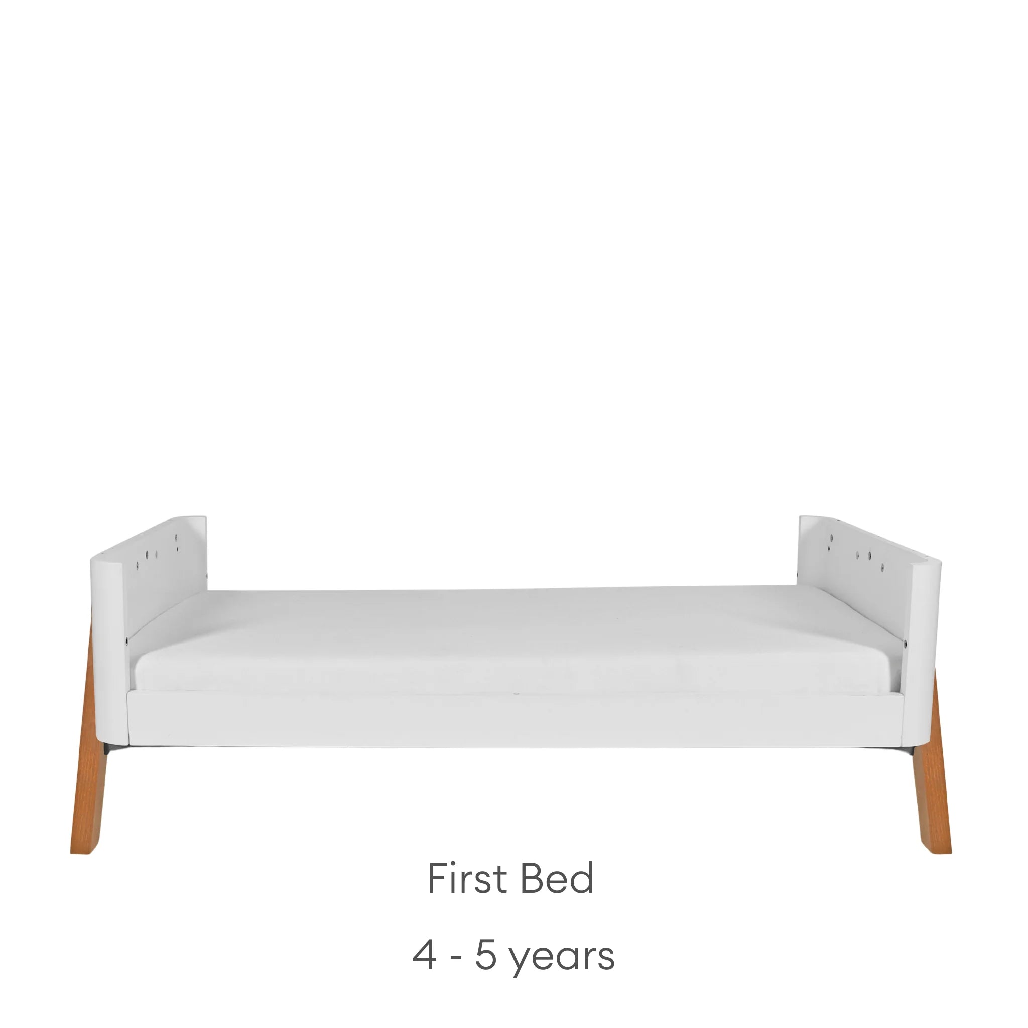 Gaia Baby Hera cot bed converted into a first bed in white and oak, with low side panels and wooden legs, suitable for young children, shown on a white background.