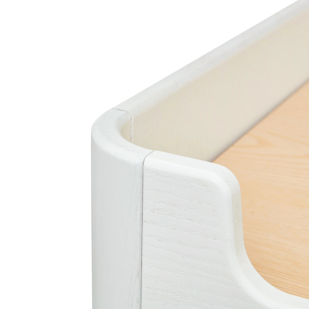 Close up angled view of the top of Gaia Baby Hera wardrobe scandi white showing real wood grain and smooth curved edges.