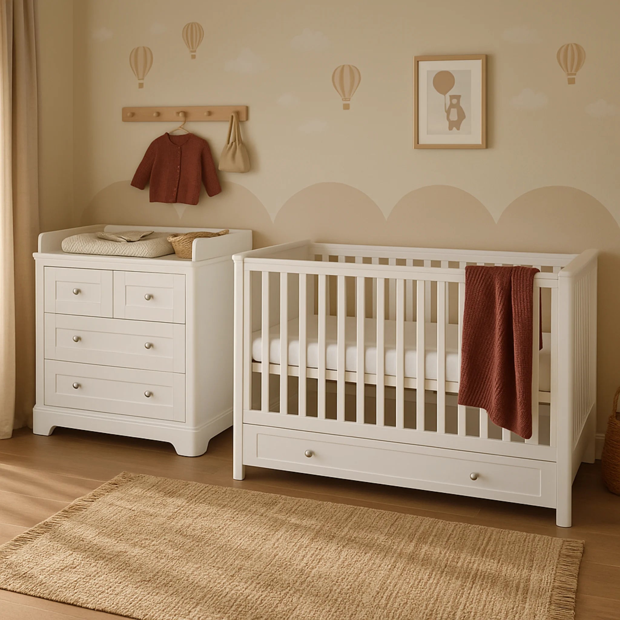 Nursery room with white cot and changing table against a beige wall with hot air balloon decorations.