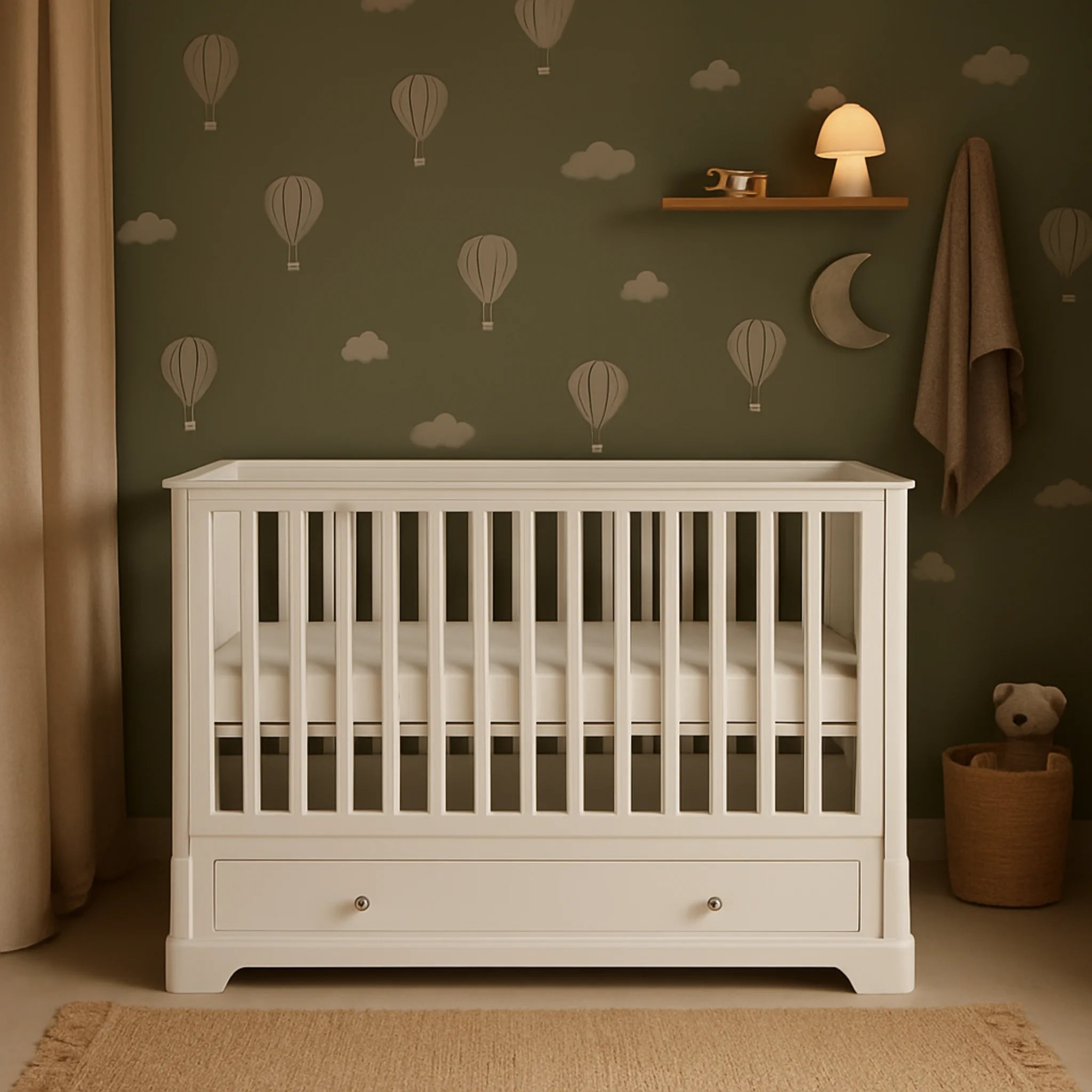 White cot in a room with green walls featuring hot air balloons and clouds, a teddy bear, and a lamp.