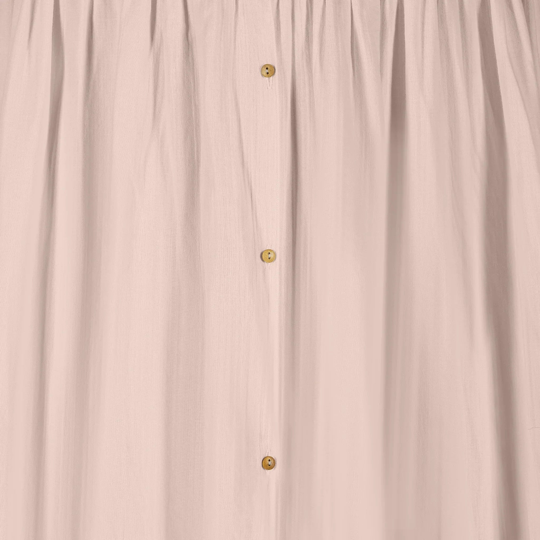 Detail of blush muslin baby canopy with button fastening, soft breathable cotton fabric for nursery décor by Gaia Baby.
