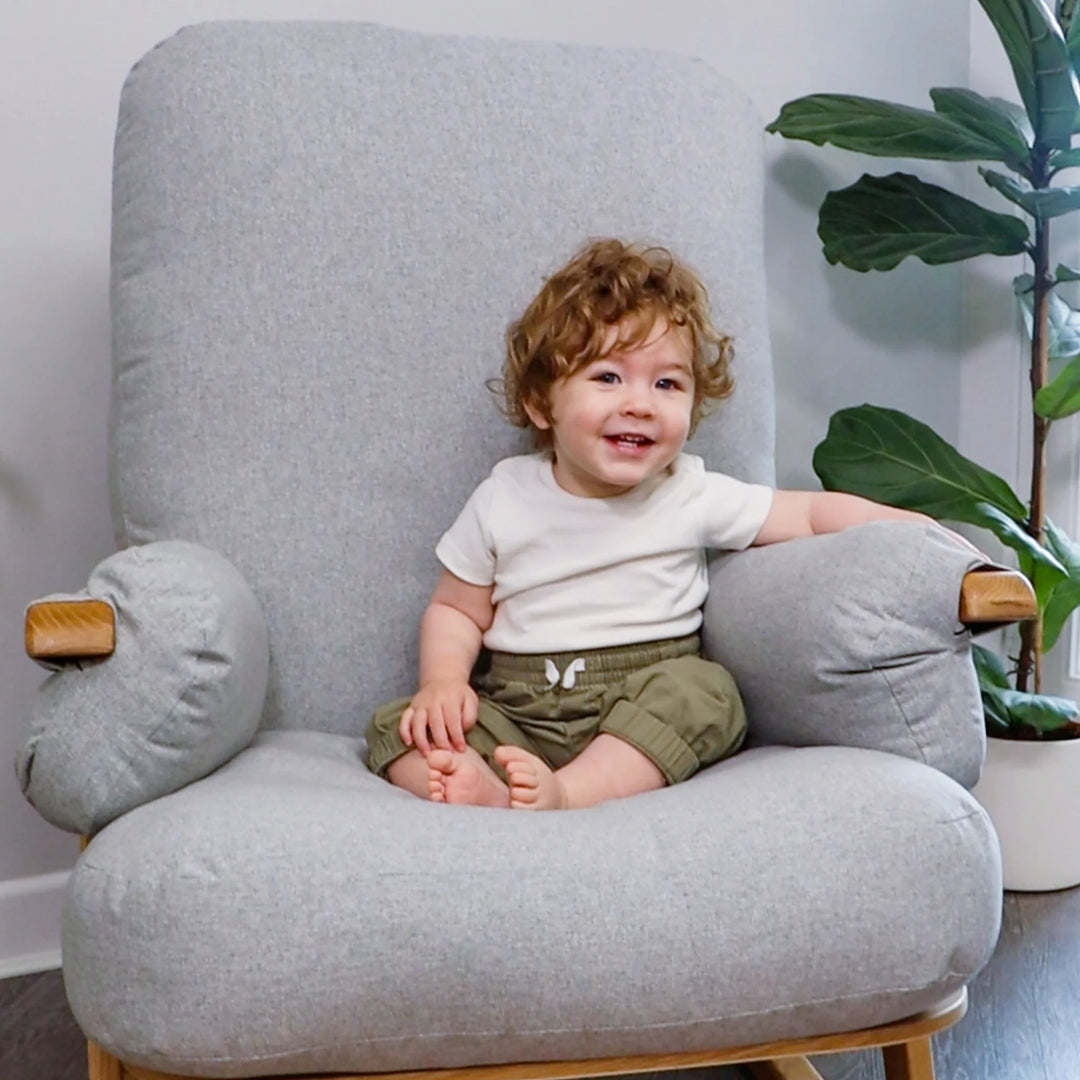 Gaia Baby Hera Rocking Chair in Dusk with child sitting in deep, hand-filled cushions.