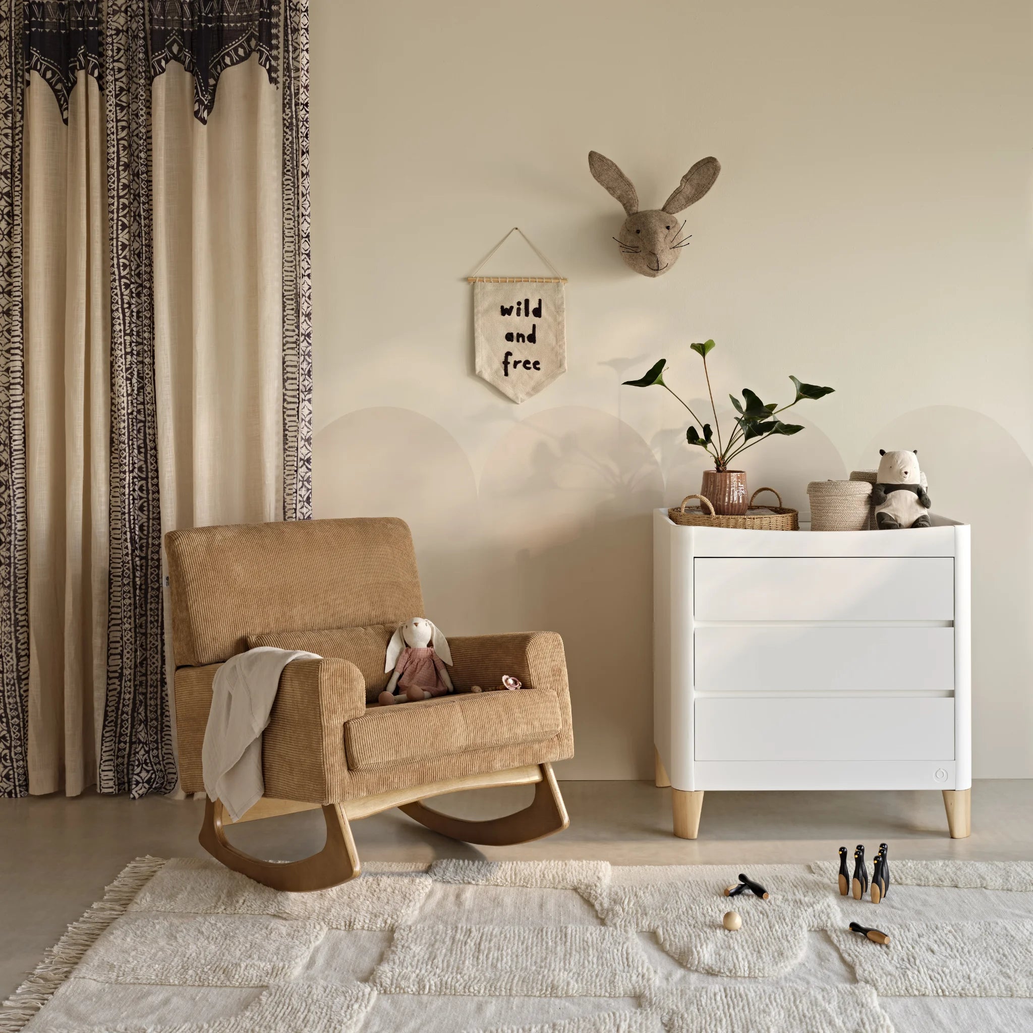 Gaia Baby Serena Rocking Chair in caramel upholstery beside the Serena Dresser in a contemporary nursery, featuring premium nursery seating, Scandinavian-inspired baby furniture and modern nursery décor.