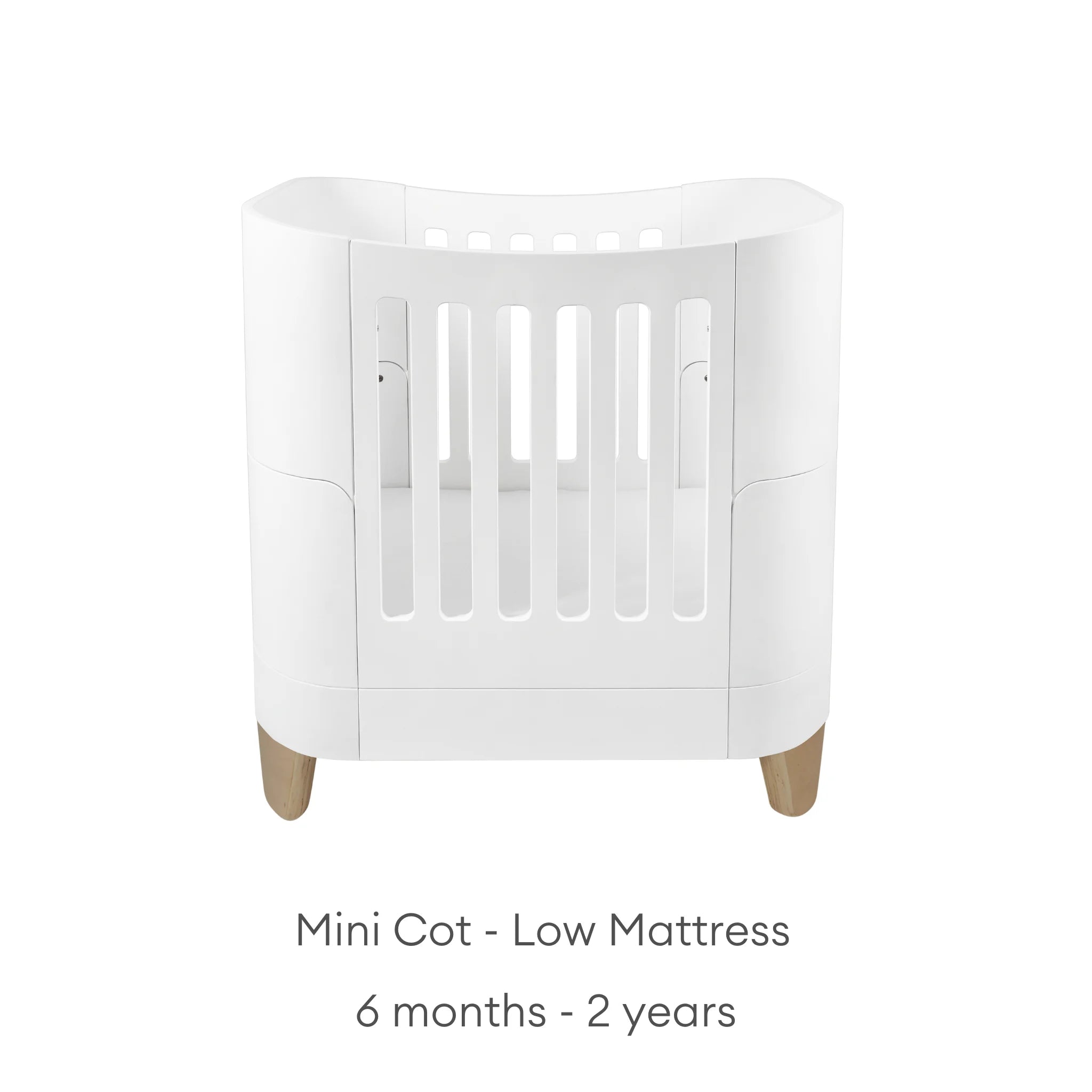 Serena Mini Cot with low mattress setting and natural wood legs, white toddler crib by Gaia Baby for 6 months to 2 years.