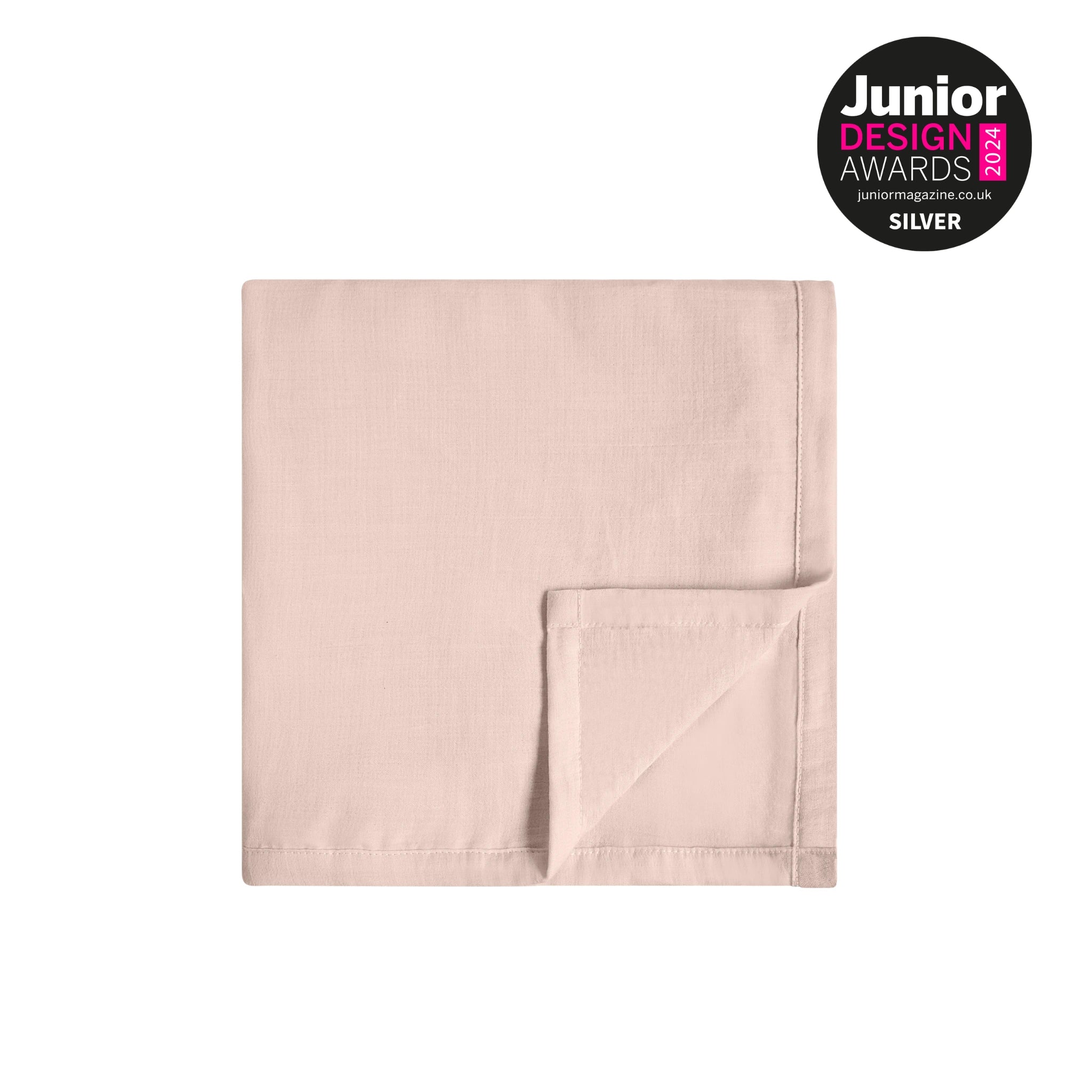 Gefaltete rosafarbene Musselin-Babydecke auf einem klaren, hellen Hintergrund mit dem silbernen Abzeichen der Junior Design Awards 2024 in der Ecke.