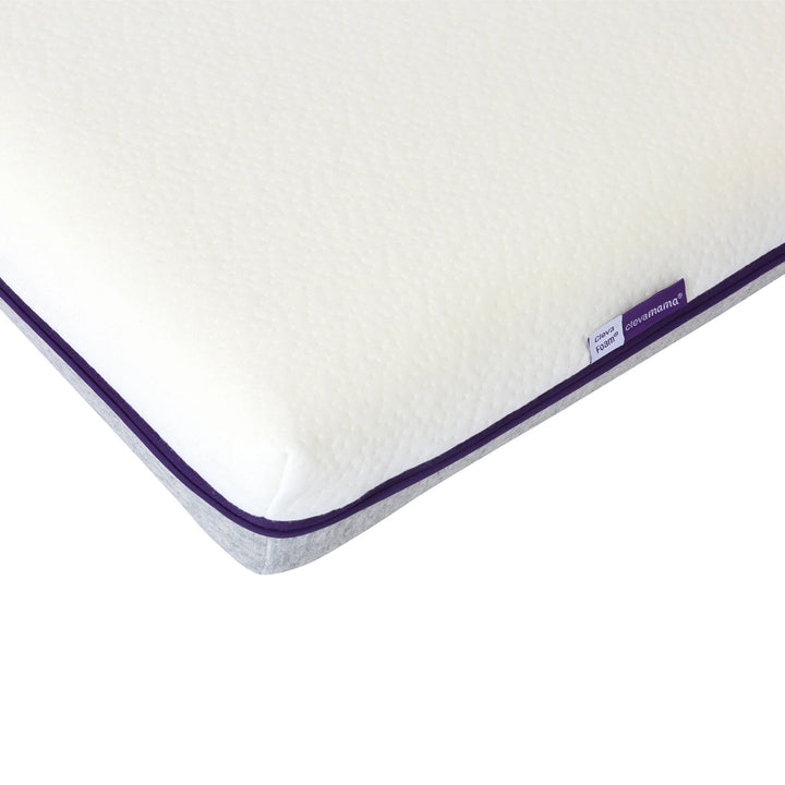 Close-up detail of ClevaMama ClevaFoam support cot mattress showing textured breathable cover and reinforced corner edge.