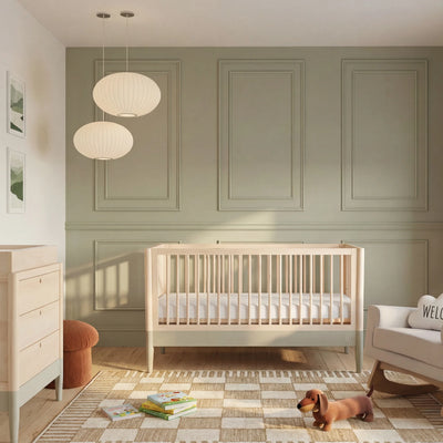 Gaia Baby EOS natural wood convertible cot bed styled in modern nursery room with dresser and toys