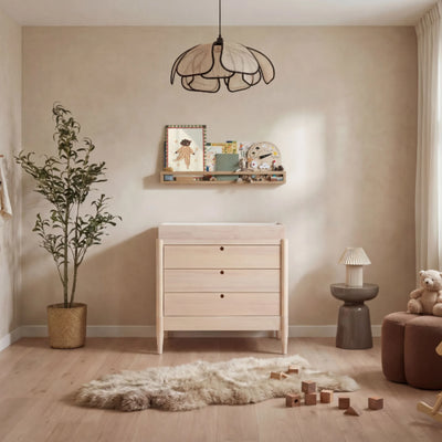 Gaia Baby EOS Kinderzimmerkommode aus Naturholz mit Wickeltisch in einem stilvollen, modernen Babyzimmer.