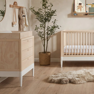 Gaia Baby EOS nursery dresser with changing top in natural wood and white styled in a modern nursery