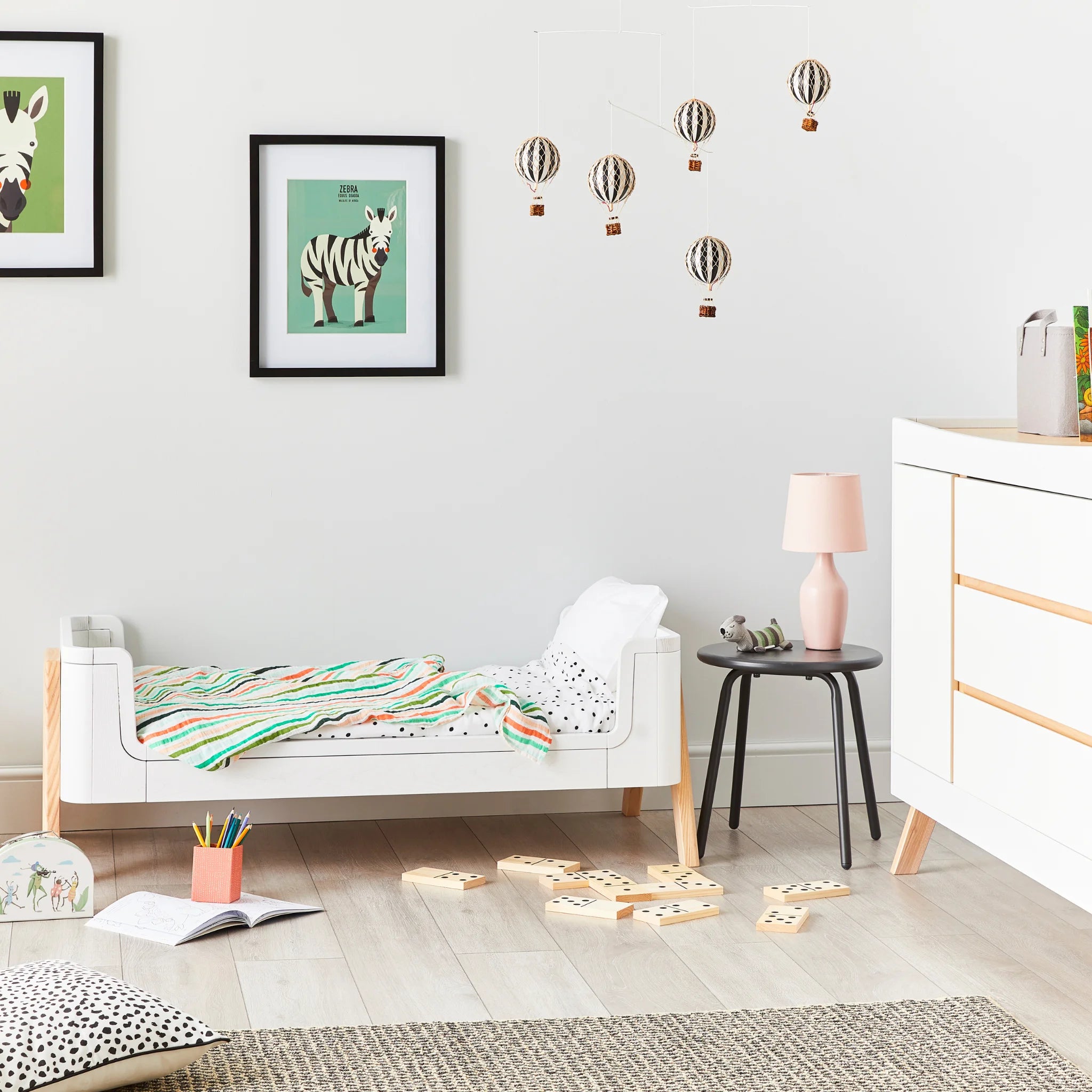 Hera ledikantbed in eerste bed-modus met comfortabele kussens en dekens en bijpassend dressoir.