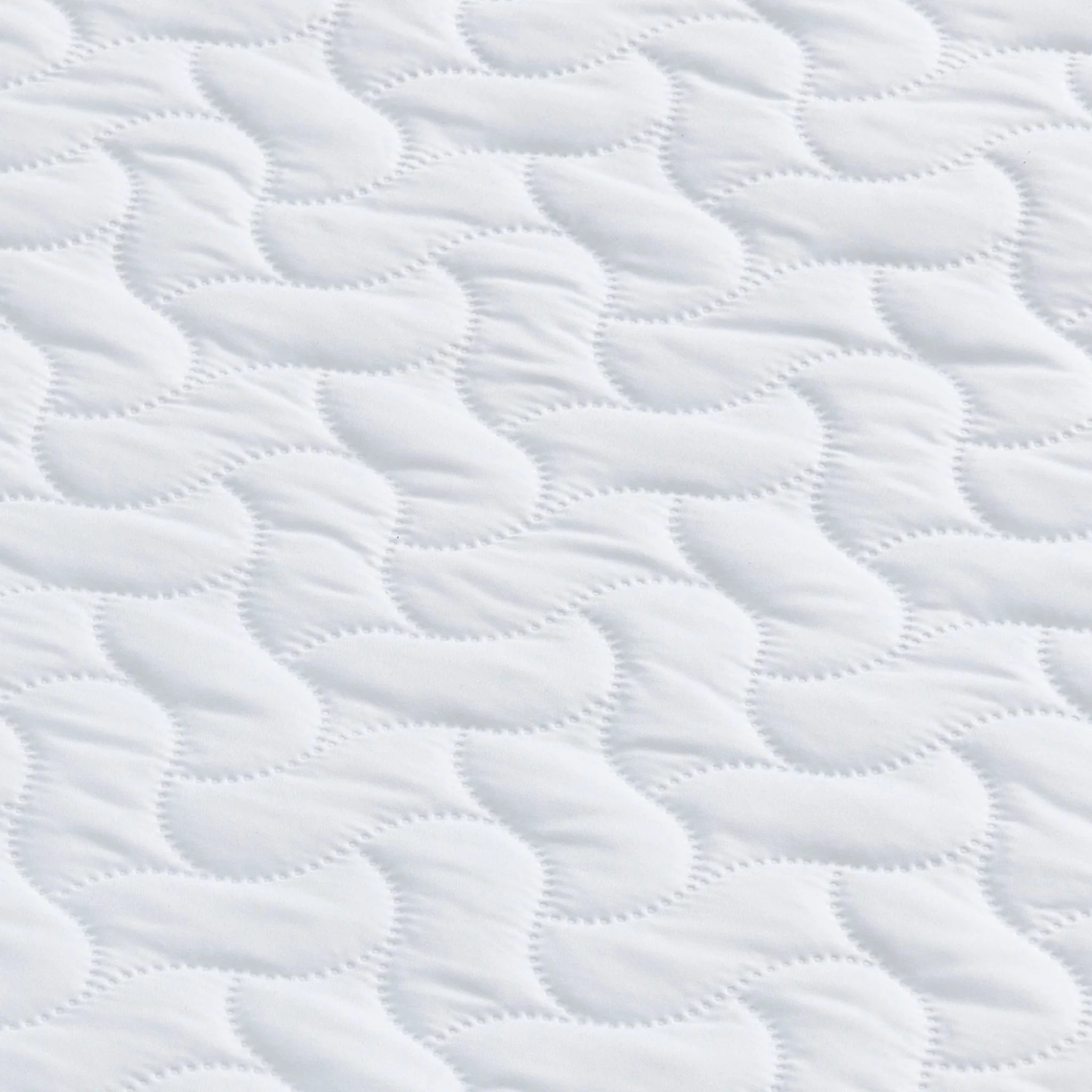 Close up of the surface of the Hera Cot Bed Mattress and wavy pattern.