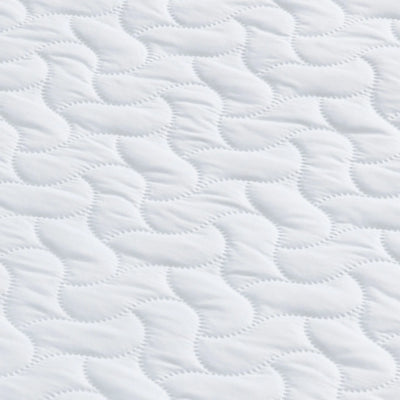 Close up of the surface of the Hera Cot Bed Mattress and wavy pattern.