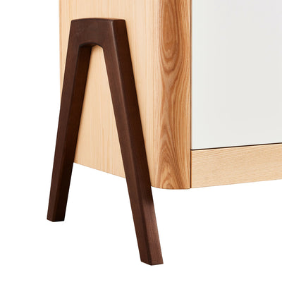 Close up of the real walnut wood a-frame legs on the Gaia Baby Hera Dresser in white natural.