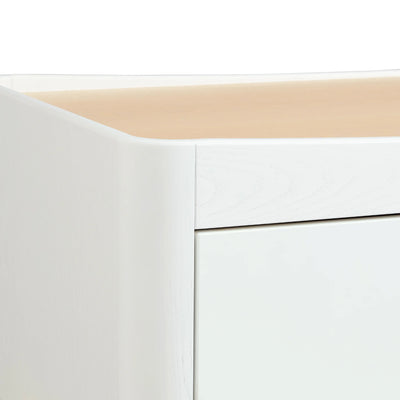 Close up of wood grain and curved edges on the Gaia Baby Hera Dresser in scandi white.