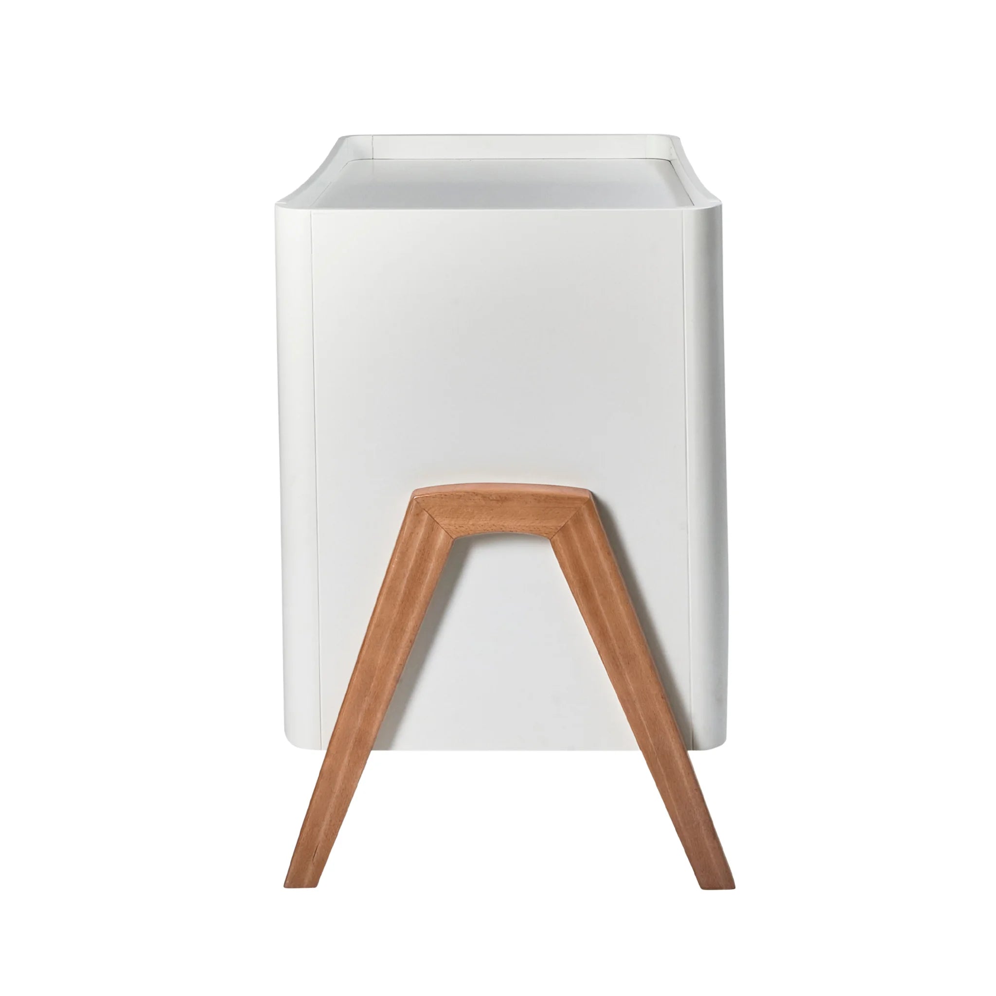 Side view of the Gaia Baby Hera dresser in white and oak, highlighting the smooth curved body and distinctive A-frame wooden leg detail, shown on a white background.