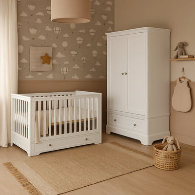 Nursery room with white cot and wardrobe against a wall with cloud and hot air balloon pattern.