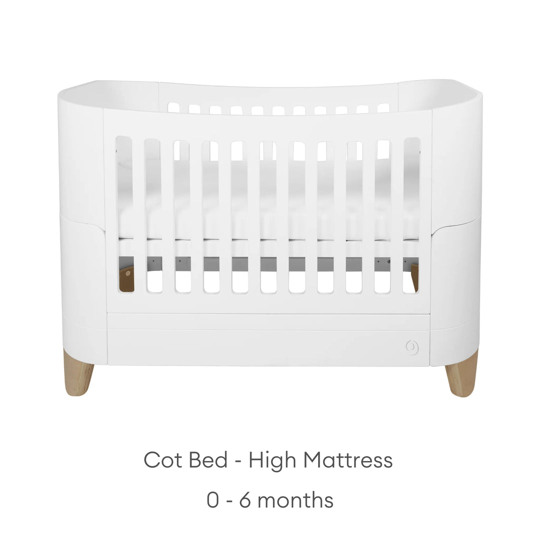 Product image of the Gaia Baby Serena cot bed with natural wood legs shown in high mattress position for newborn mode, featuring a clean white background and minimalist presentation with age range indication for 0–6 months.