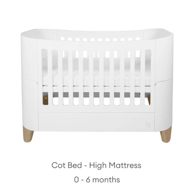 Front view of the white Serena cot bed in high mattress mode for newborns aged 0–6 months, featuring natural wood legs and a minimalist modern design.