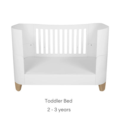 Gaia Baby Serena Cot Bed in toddler bed mode with natural wooden legs, white toddler bed suitable for 2–3 years.