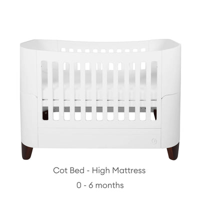 Gaia Baby Serena Kinderbett mit Beinen aus Walnussholz und hoher Matratzenhöhe, modernes weißes Babybett für Neugeborene im Alter von 0–6 Monaten, minimalistisches Produktbild von Kinderzimmermöbeln auf einem sauberen weißen Hintergrund.