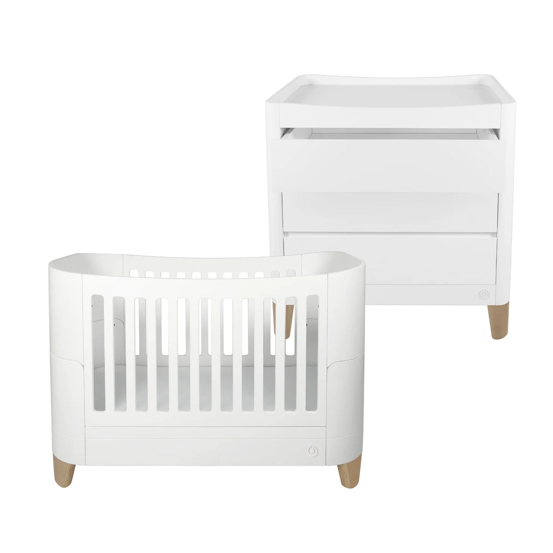 Modern nursery furniture set featuring the Gaia Baby Serena cot bed and matching changing dresser with natural wood legs, styled in a clean minimalist aesthetic on a white background.