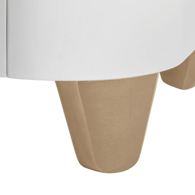 Close-up detail of the Serena cot bed’s natural wood leg beneath the smooth curved white frame, shown on a clean white background.