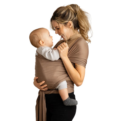 Mutter hält Baby in dehnbarem Gaia Baby-Wickeltuch aus muskatnussfarbener Bio-Baumwolle, einander zugewandt