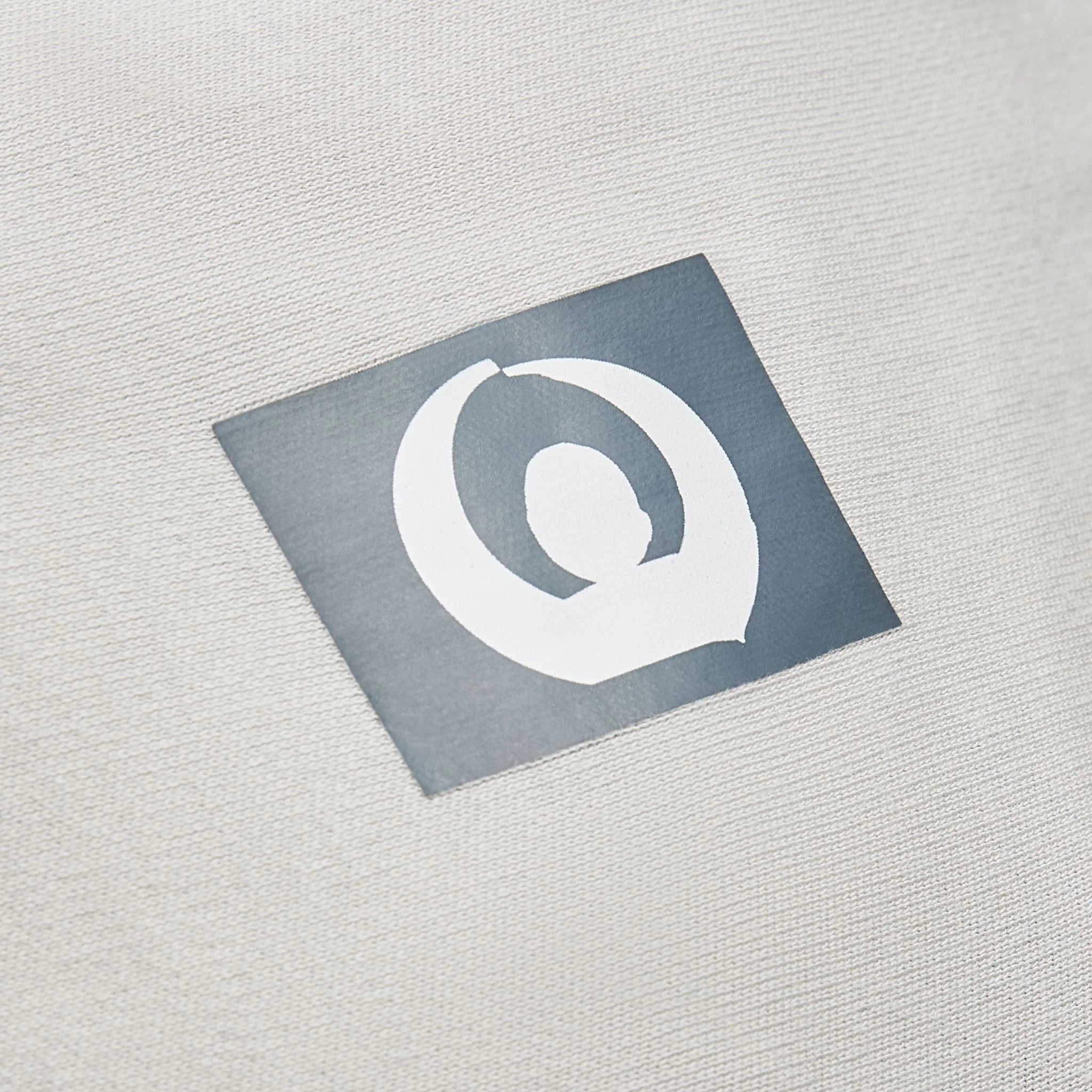 Close-up of Gaia Baby logo on silver grey organic cotton stretchy baby wrap carrier fabric