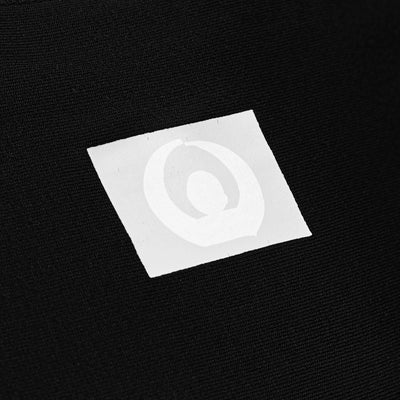 Close-up of Gaia Baby logo label on black stretchy wrap fabric.