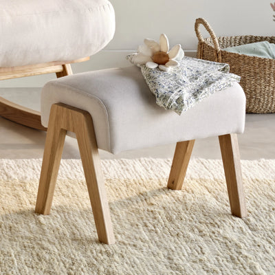Hera Footstool in Barley colour with wooden legs, upholstered nursery footrest by Gaia Baby with soft neutral styling.
