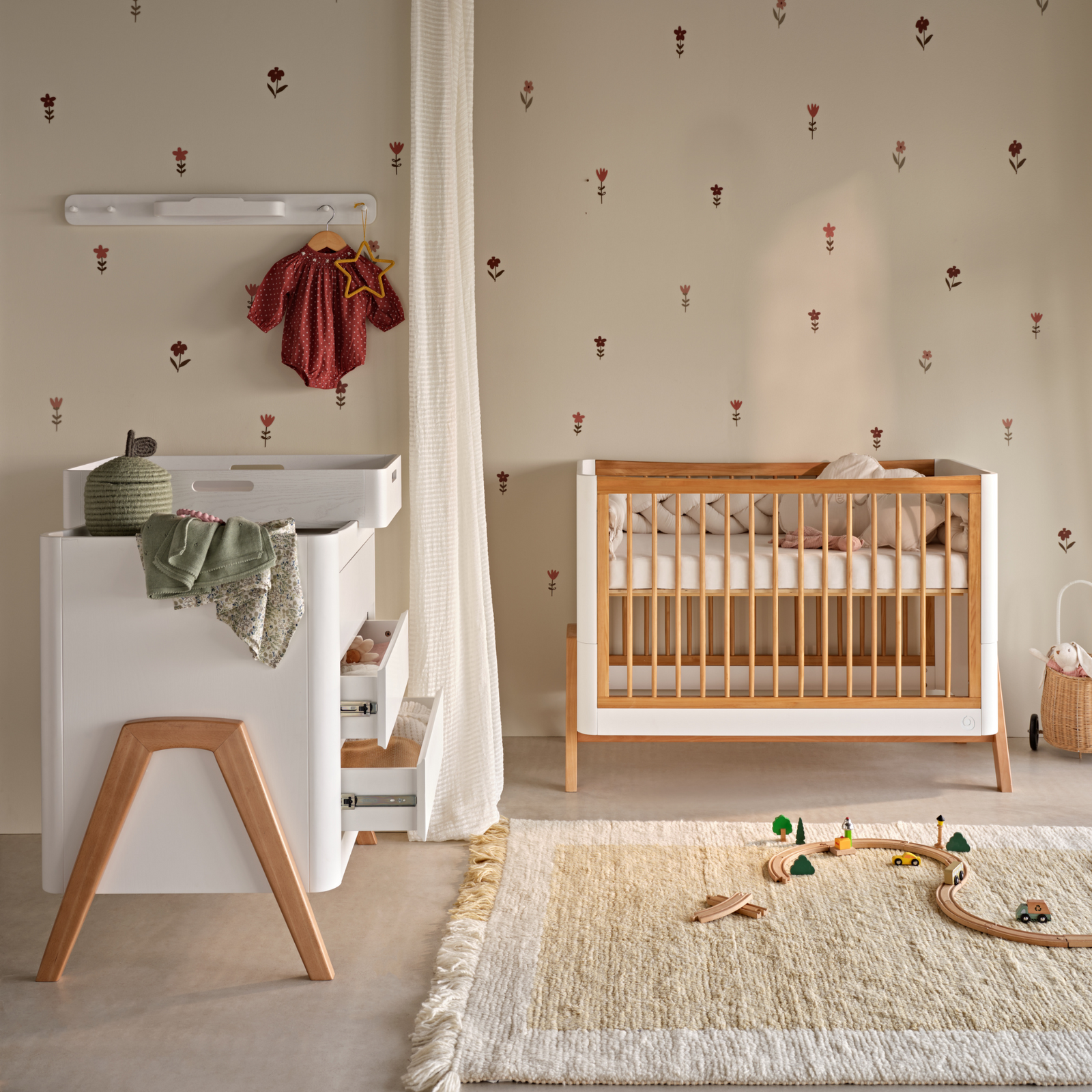 Hera Studio Edit Cot Bed and Dresser in Natural oak with the Hera changing station and peg rail in white in a neutral modern nursery.