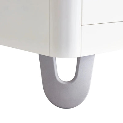 Close-up of Gaia Baby Serena white dresser leg with curved metal base detail