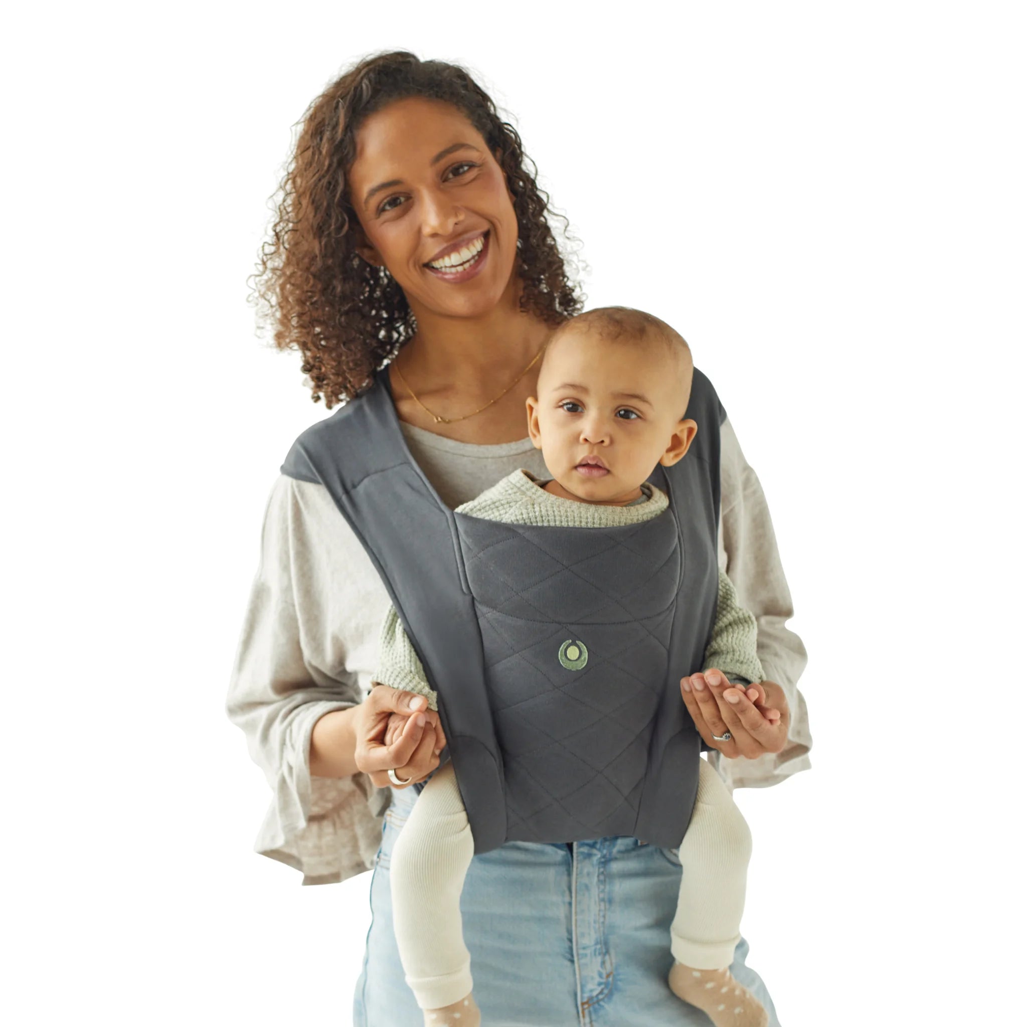 Mujer cargando a su bebé en la mochila portabebés Gaia Baby Soft Newborn Plus en grafito en posición orientada hacia el mundo
