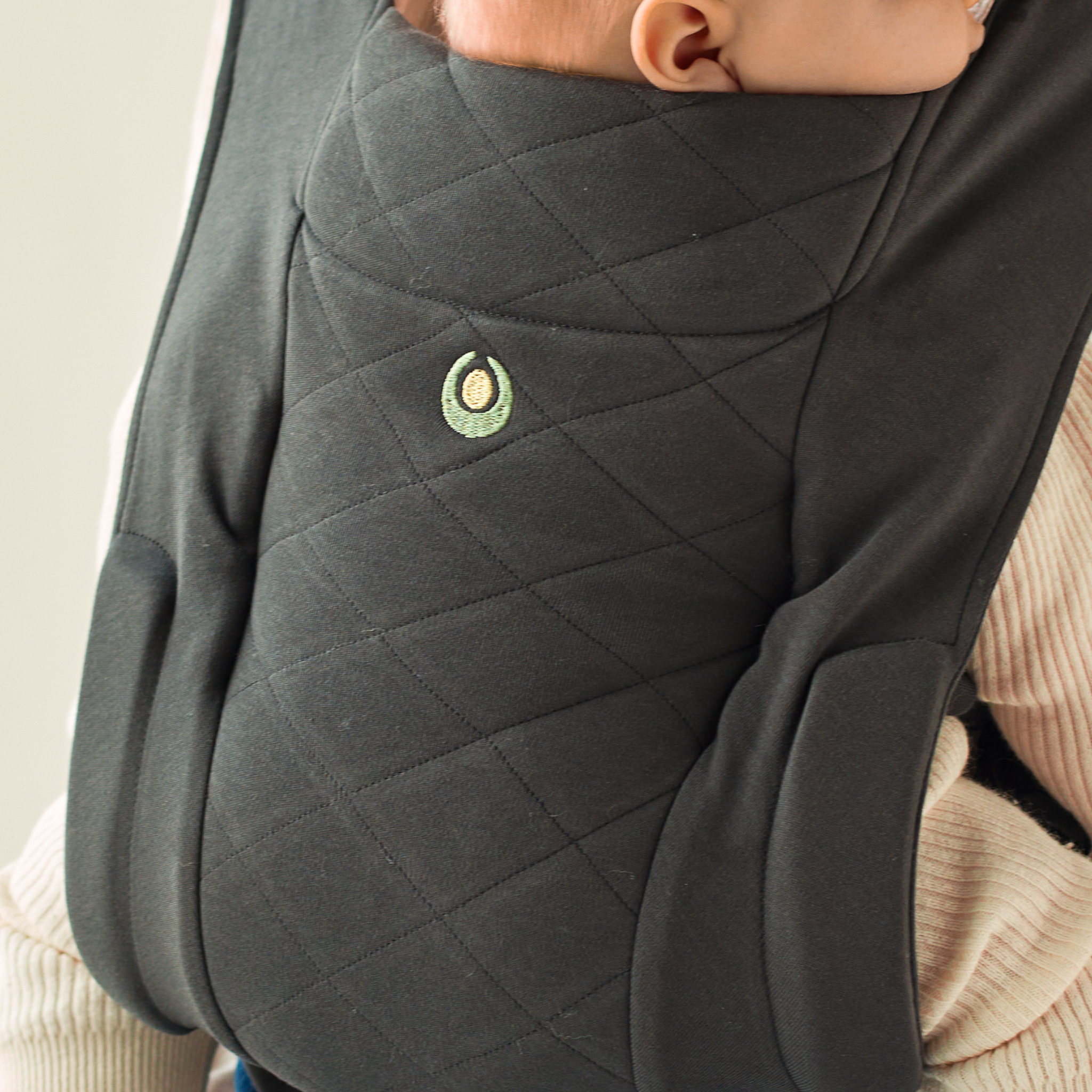 Primer plano de los detalles del acolchado de la mochila portabebés Gaia Baby Newborn Plus de algodón orgánico en grafito