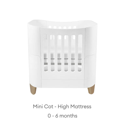 Gaia Baby Serena Mini Cot with natural wooden legs and high mattress position, white baby crib suitable for newborns 0–6 months.