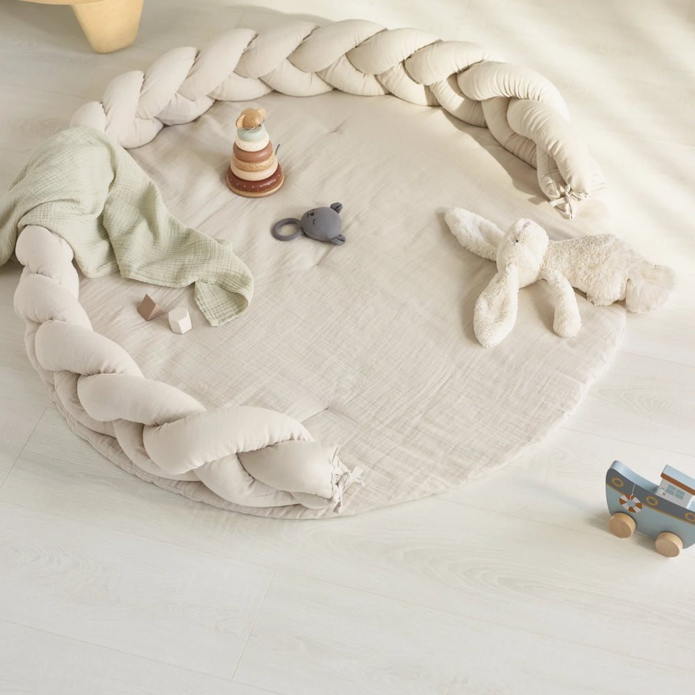 A lifestyle image of a baby play corner showing Gaia baby Maia muslin braided pillow and Maia Playmat