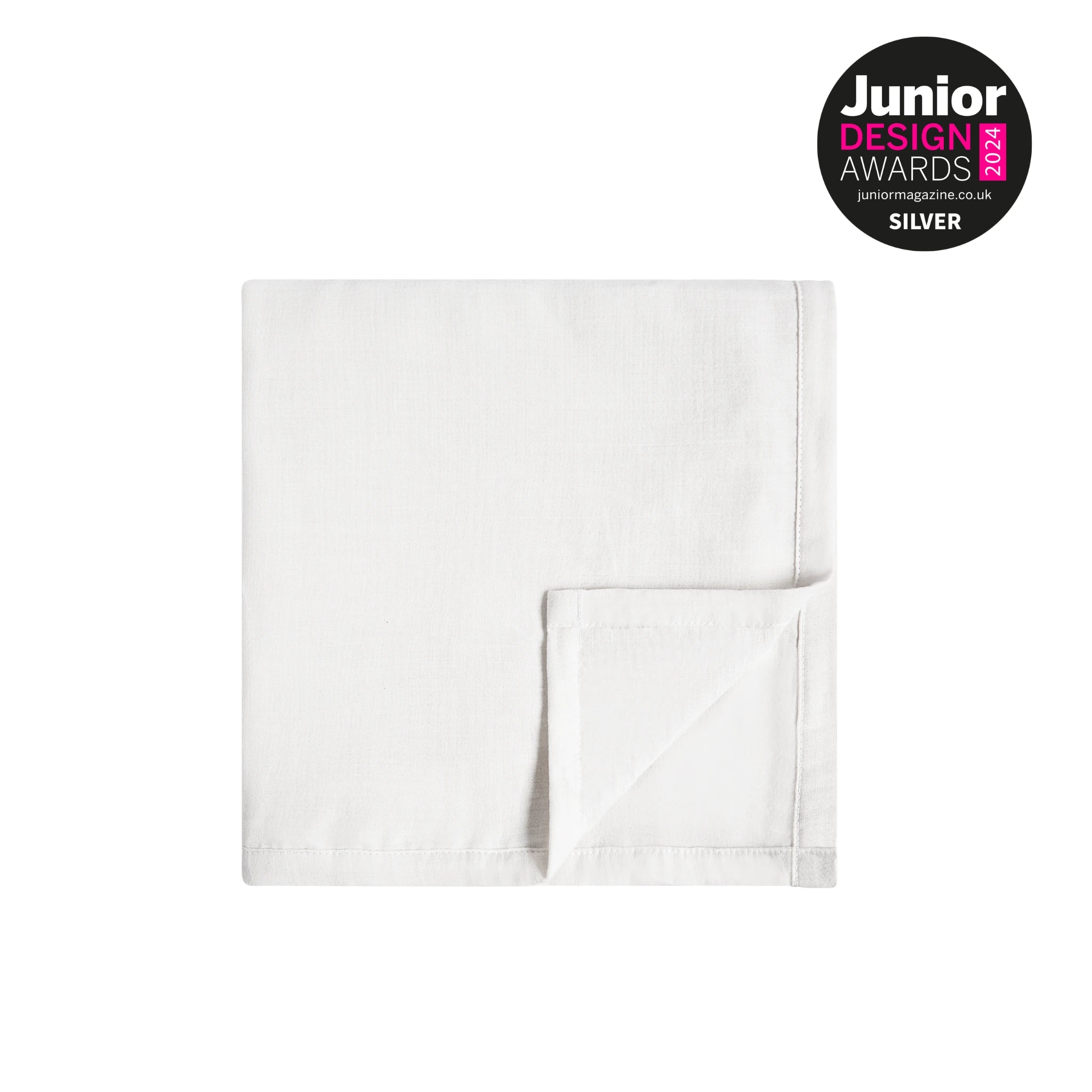 Folded soft white muslin baby blanket on a light neutral background with Junior Design Awards 2024 Silver badge displayed in the corner.
